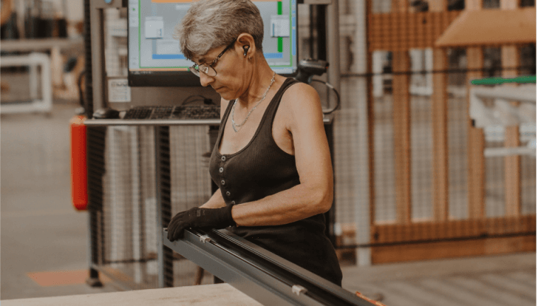 Salariée réalisant le contrôle d'un profilé en aluminium dans un atelier de fabrication