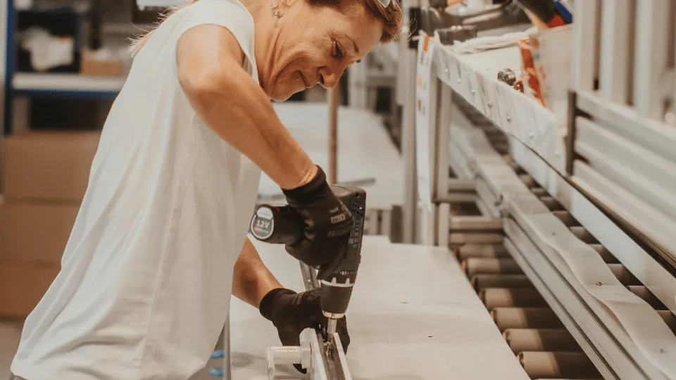 Photo d'une salariée Baie vision au cœur de l'usine en train de visser